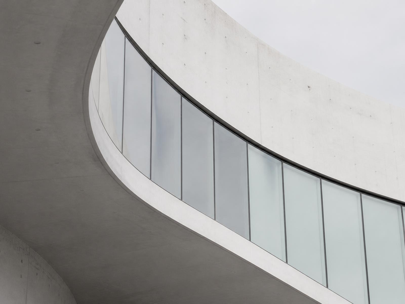 Fachada arquitectónica curva en hormigón y vidrio